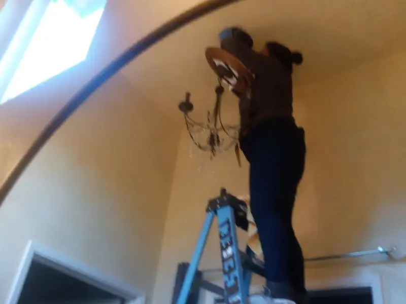 Electrician installing a chandelier in a Candlewick Lake residence